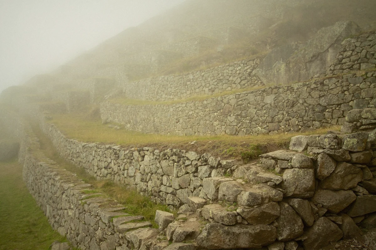 Morning mist shrouding the terraces of Machu Picchu in the Cusco Region of Peru
