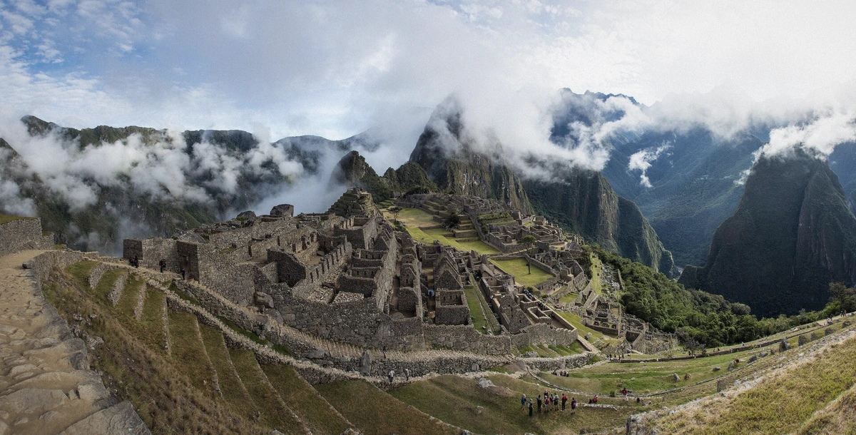 Panorama of Machu Picchu under drifting morning mist with the peak behind, Peru