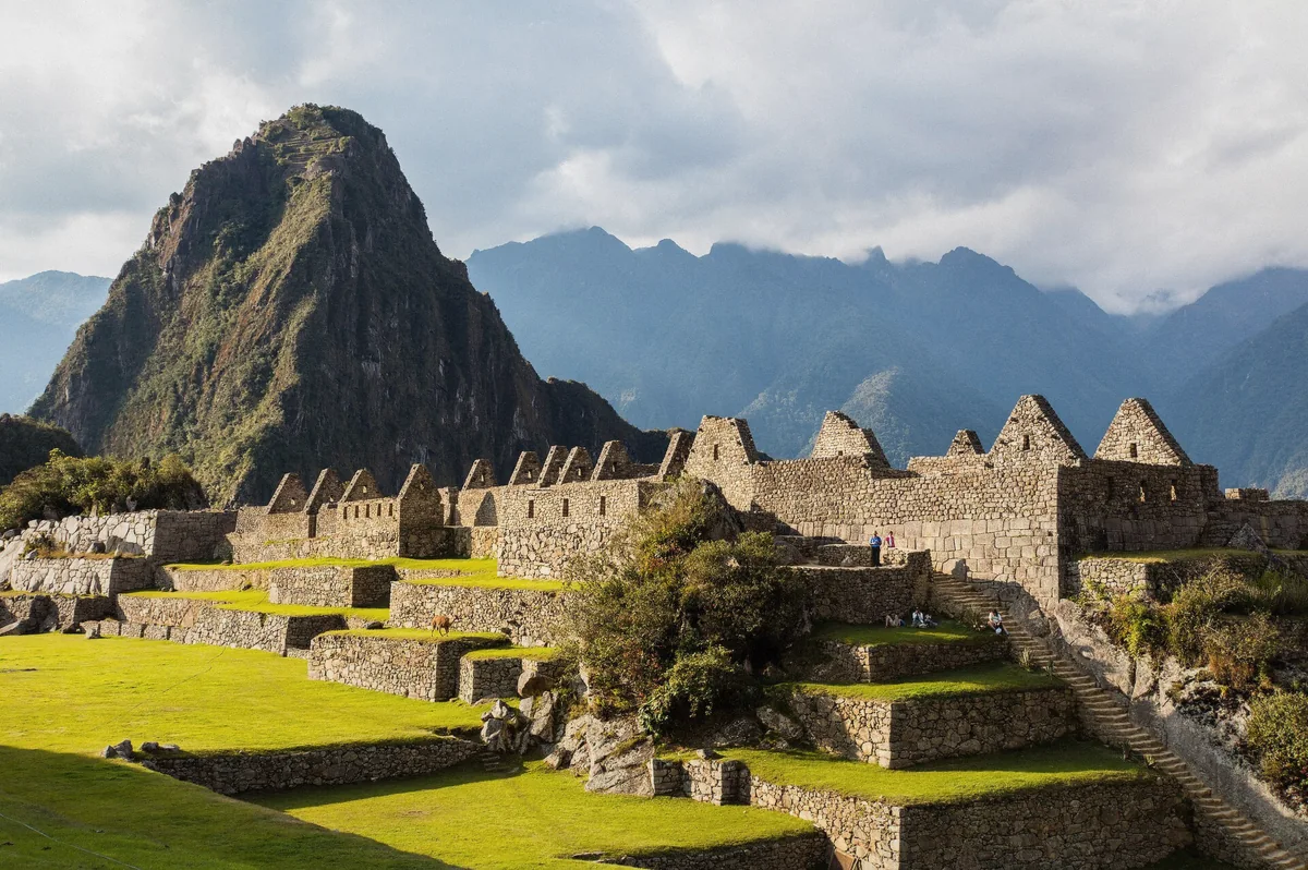 Machu Picchu citadel panorama under drifting clouds with Huayna Picchu behind, Peru