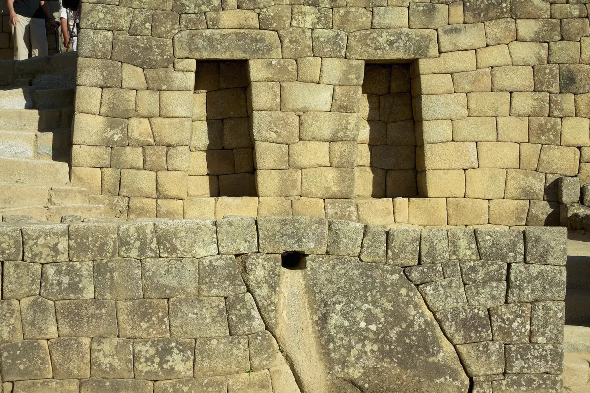 Stone aqueduct face carving at the Machu Picchu sanctuary in Peru