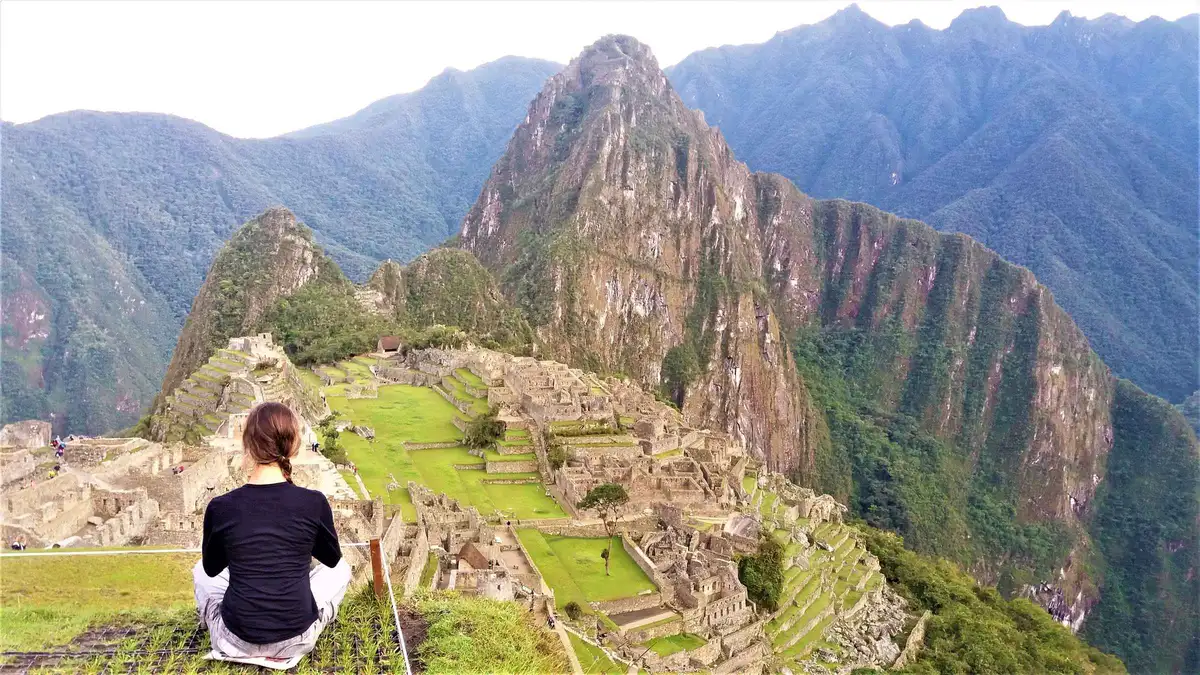 Private guide leading travellers along a stone terrace path on a Machu Picchu private tour in Peru
