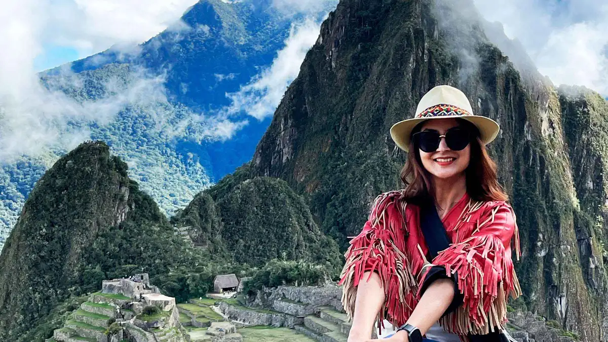 Private day trip from Cusco arriving at Machu Picchu with a guide beside the classic terraces view